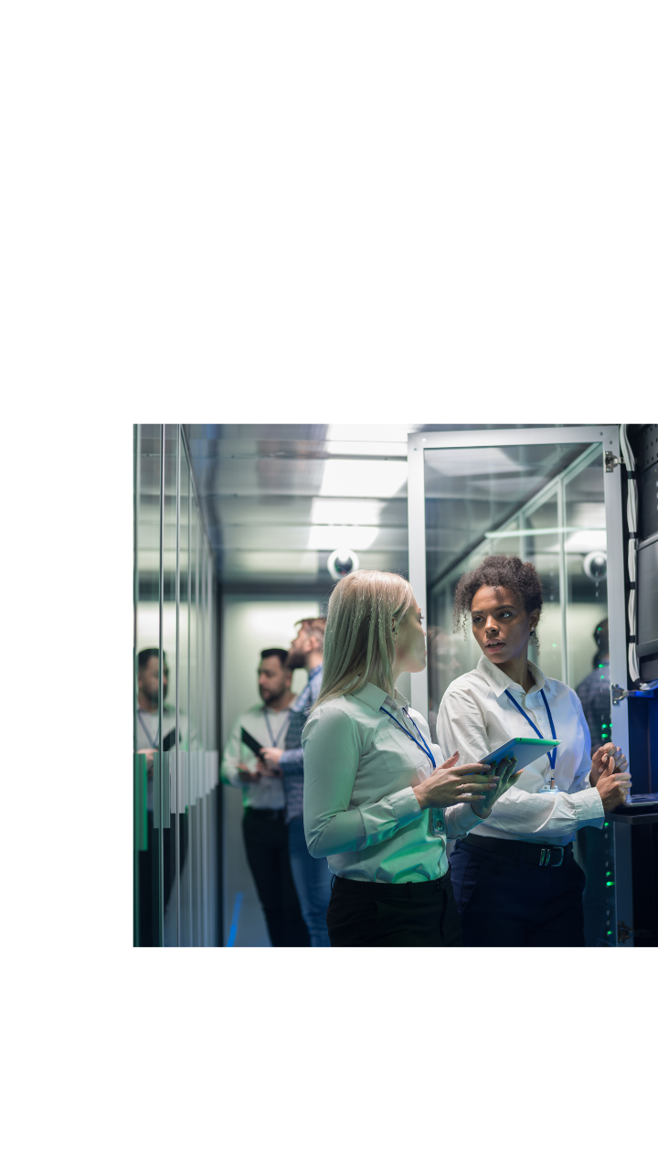 Two female professionals discussing technology in a server room, with one holding a tablet, overlaid with BDO branding and messaging on AI governance and assurance.