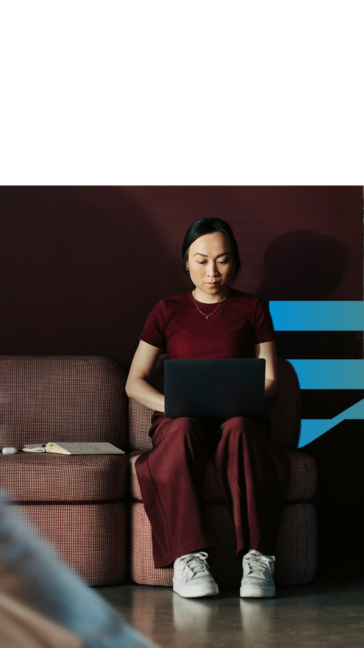 Woman working on a laptop in a modern office, representing human-centric cybersecurity awareness and workplace security behaviour. Article 3 - Are your people the…