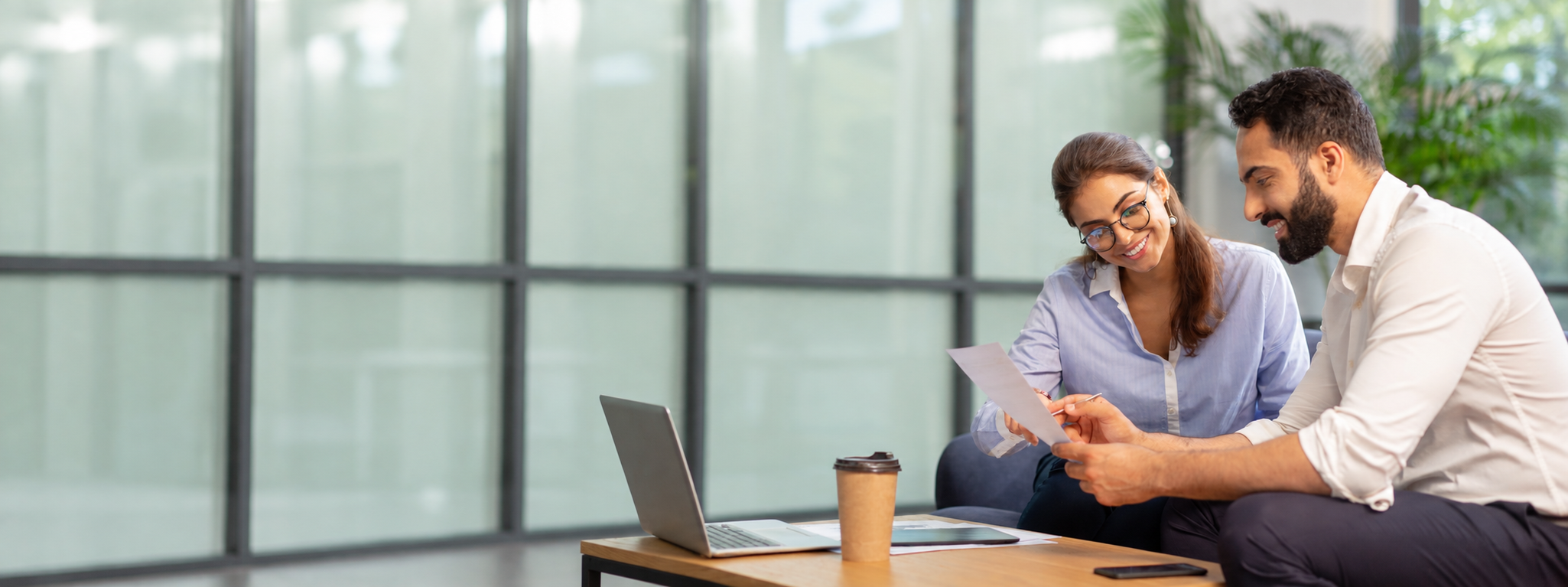 Two professionals reviewing a document together in a modern office.