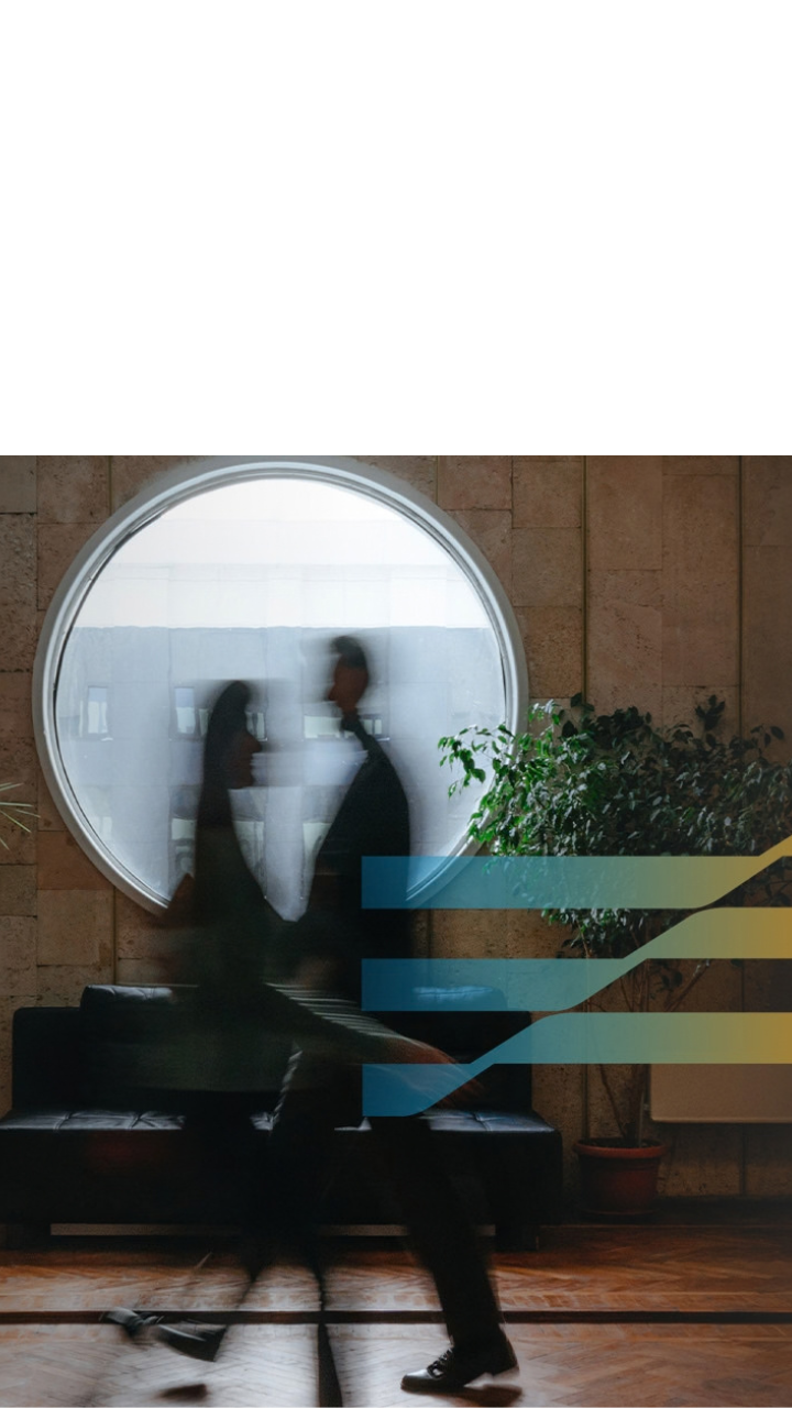 Blurred business professionals walking through a modern office with abstract digital graphics.