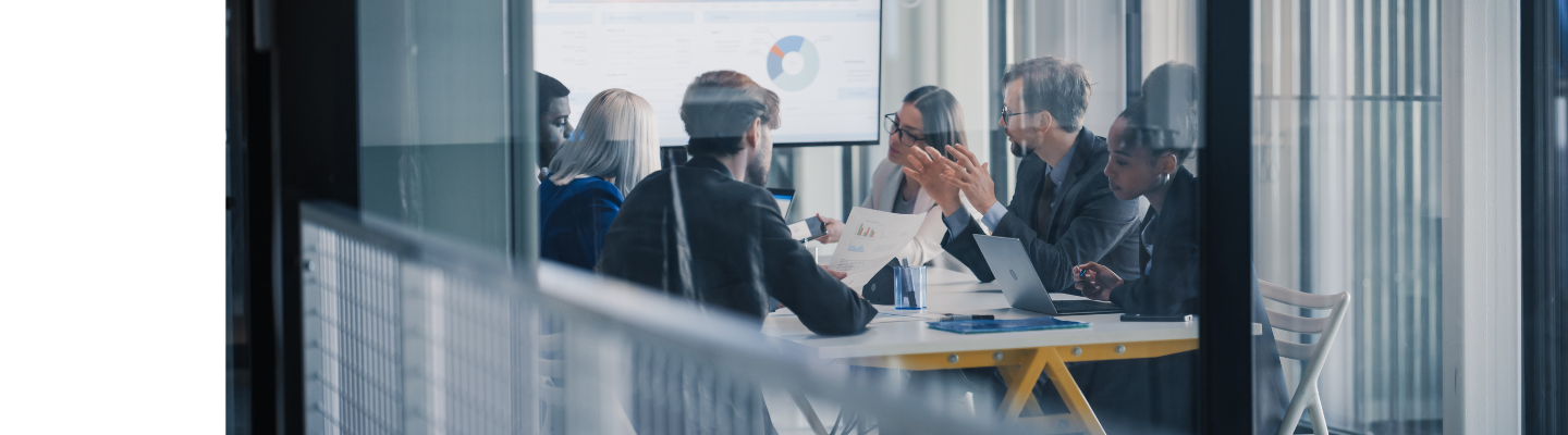 Financial services professionals discussing reports and analysing data during a meeting in a modern office.