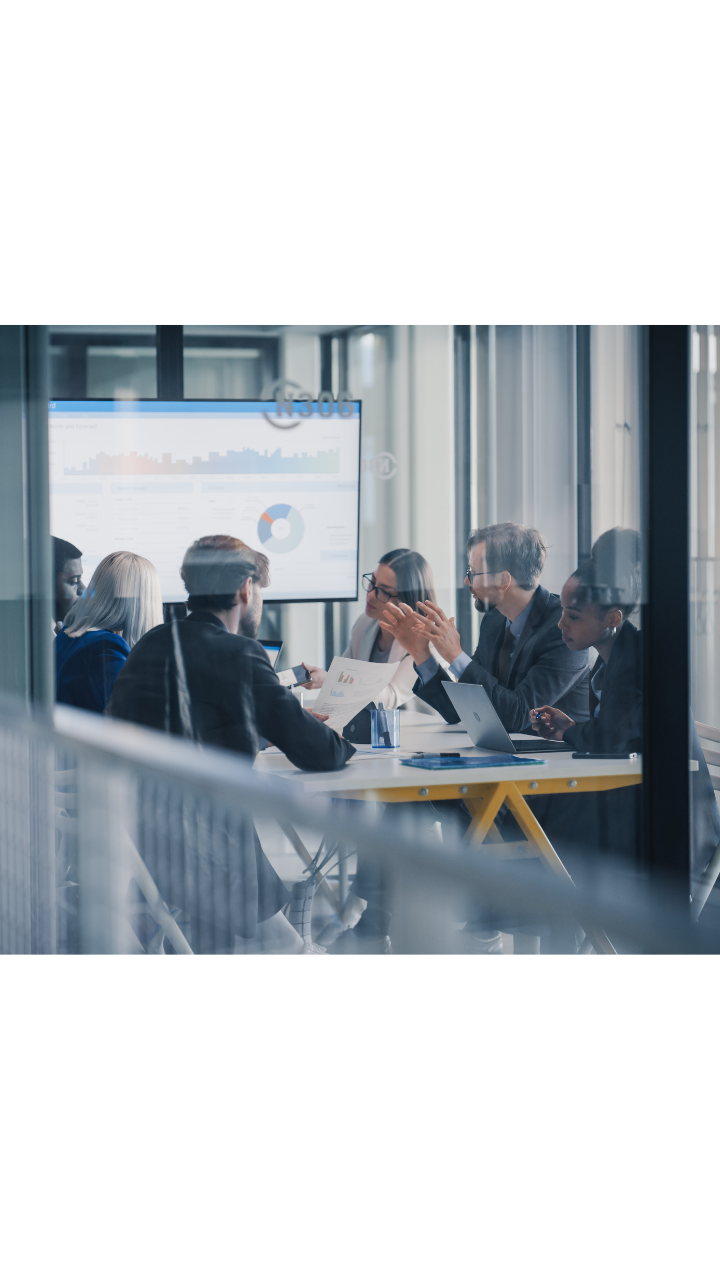 Financial services professionals discussing reports and analysing data during a meeting in a modern office.