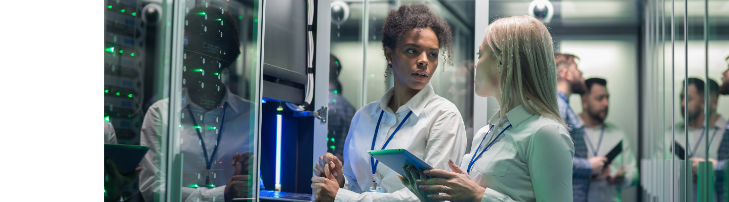 Two female professionals discussing technology in a server room, with one holding a tablet, overlaid with BDO branding and messaging on AI governance and assurance.