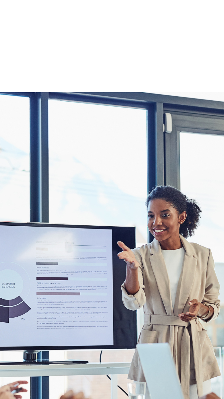 Business professionals attending a meeting while reviewing a presentation on a screen in a modern office.